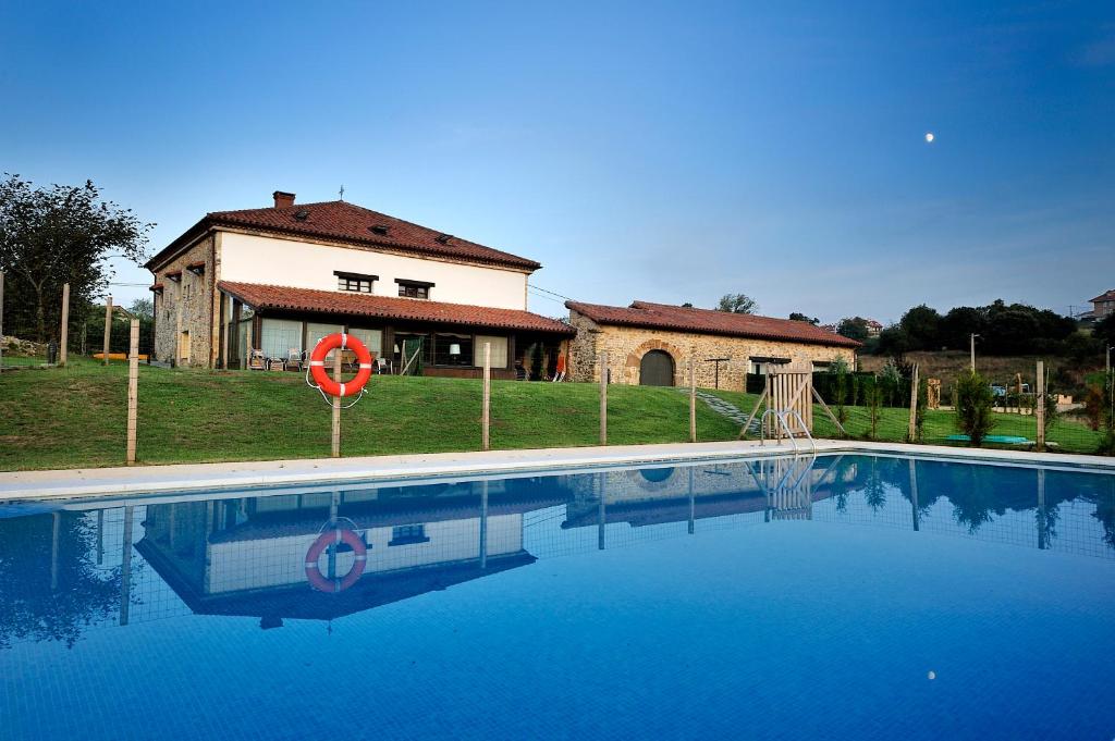 a house with a swimming pool in front of a house at Casona de la Parra in San Miguel de Meruelo