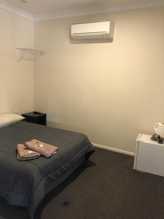 1 dormitorio con 1 cama y aire acondicionado en la pared en The Golden Dog Hotel, en Nana Glen