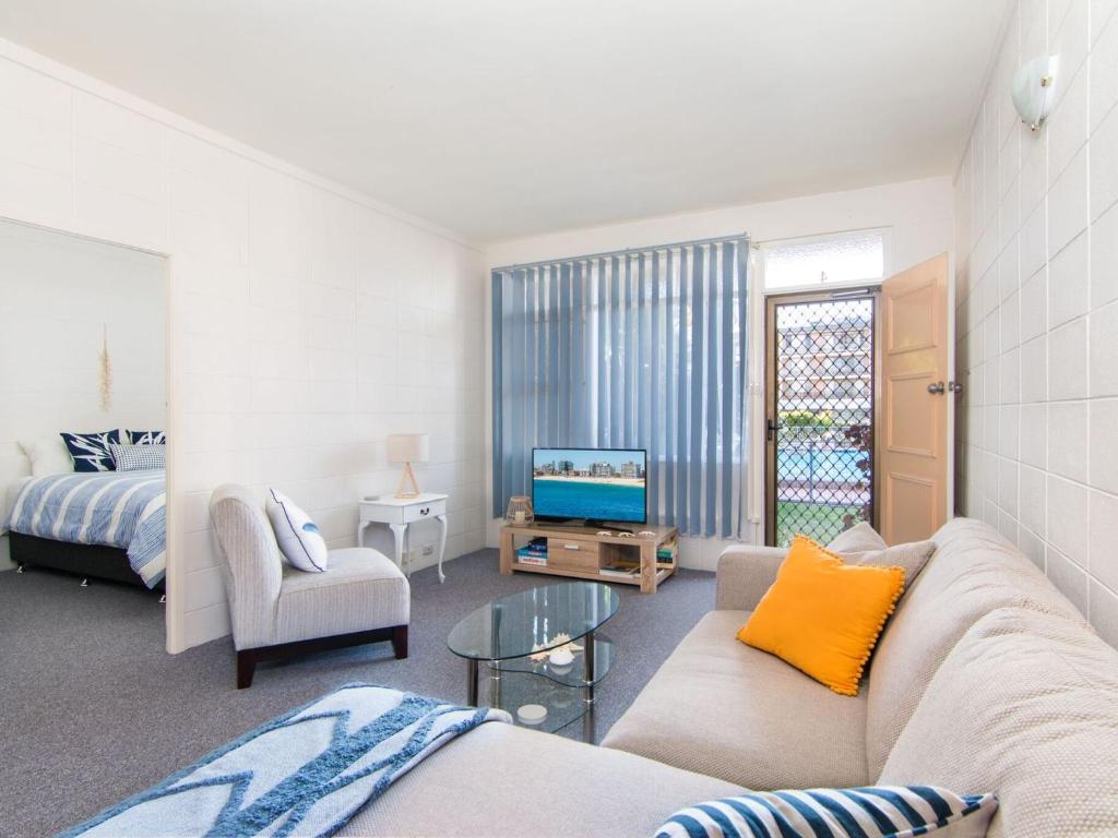 a living room with a couch and a tv at Forster Holiday Lodge 4 - Central location! in Forster