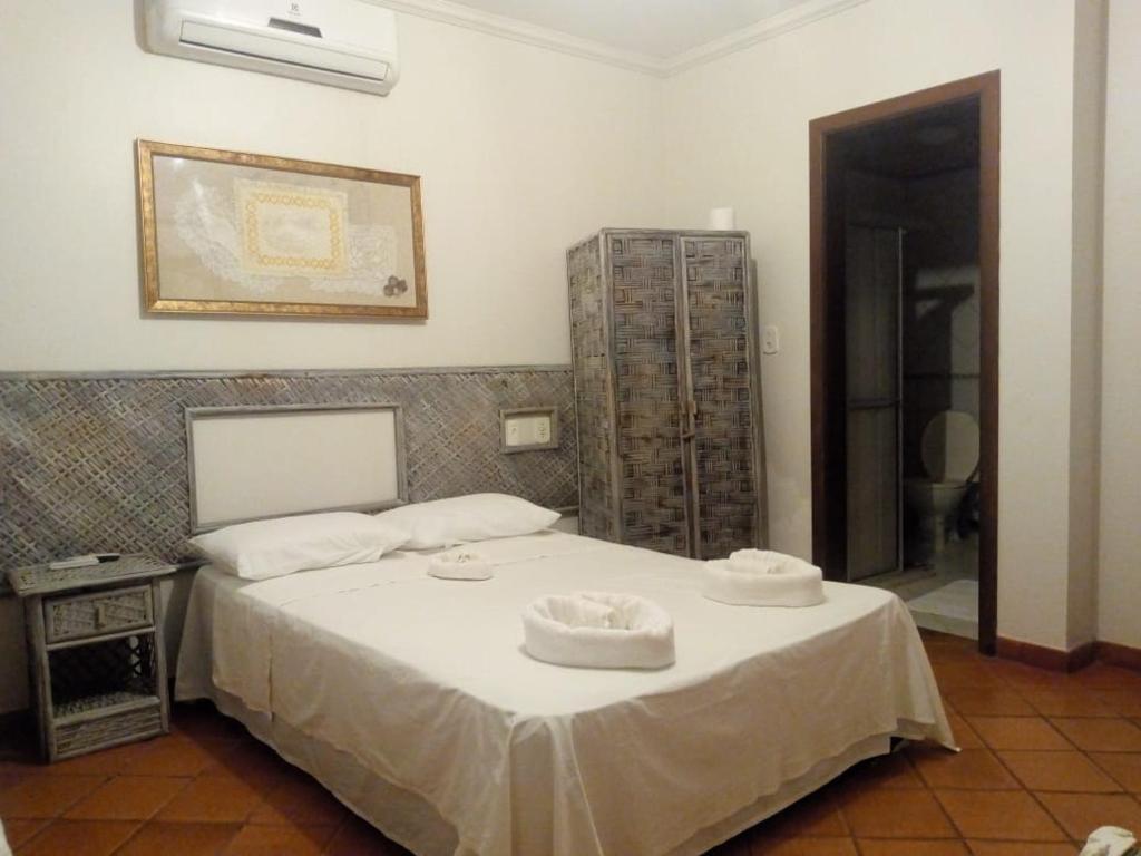 Un dormitorio con una cama con dos sombreros. en Mangue Seco Fantasias do Agreste en Mangue Sêco