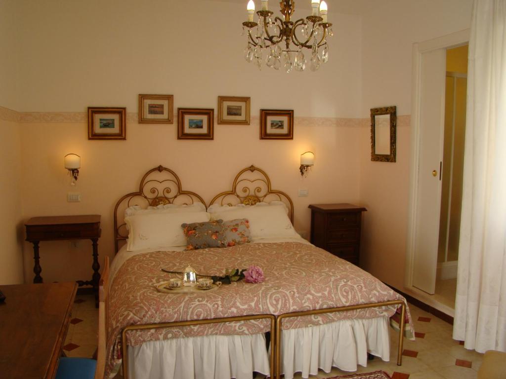 a bedroom with a bed and a chandelier at Sa Chessa B&B in Ploaghe