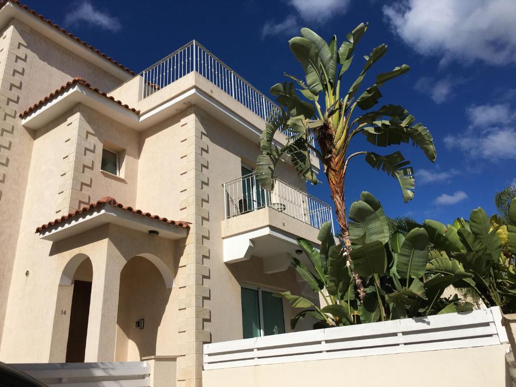 a building with a palm tree in front of it at Palma Villa 14 in Protaras