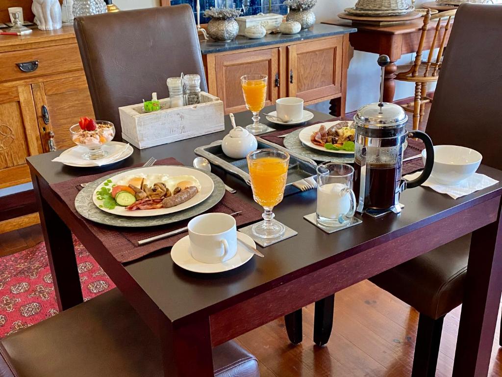 una mesa con platos de comida y bebidas. en Mountainview Guesthouse en Ciudad del Cabo