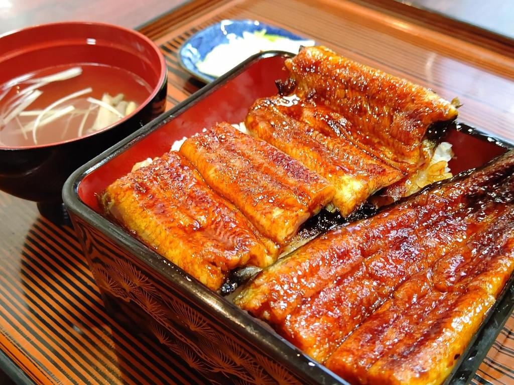 a tray of food on a table with ribs at Tabist Hamanako no Yado Kosai in Kosai