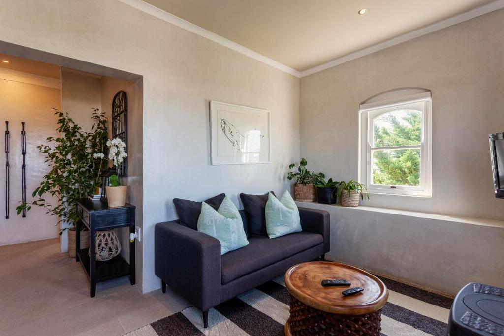 a living room with a couch and a window at Auberge Burgundy Boutique Hotel & Spa in Hermanus