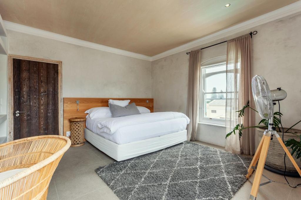 a bedroom with a white bed and a window at Auberge Burgundy Boutique Hotel & Spa in Hermanus