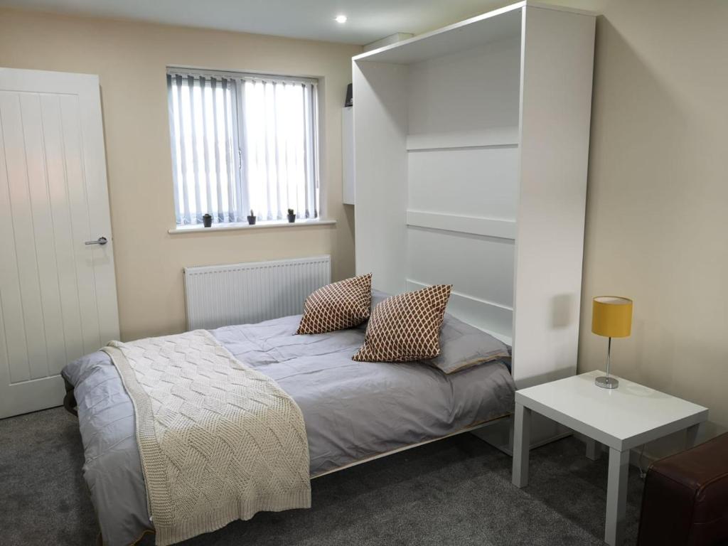 a small bedroom with a bed and a window at M60 Modern Studio Appartment with free parking in Denton
