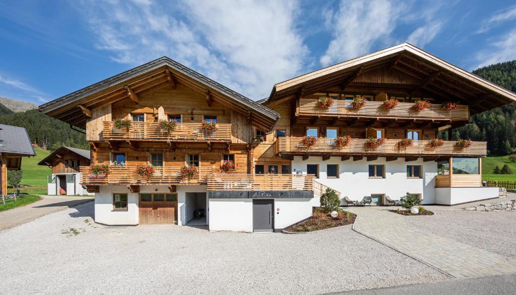 a large wooden house with balconies on it at Residence Alpina in Santa Maddalena in Casies
