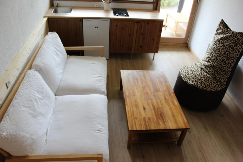 a living room with a white couch and a table at Studio tout confort au calme in La Bresse