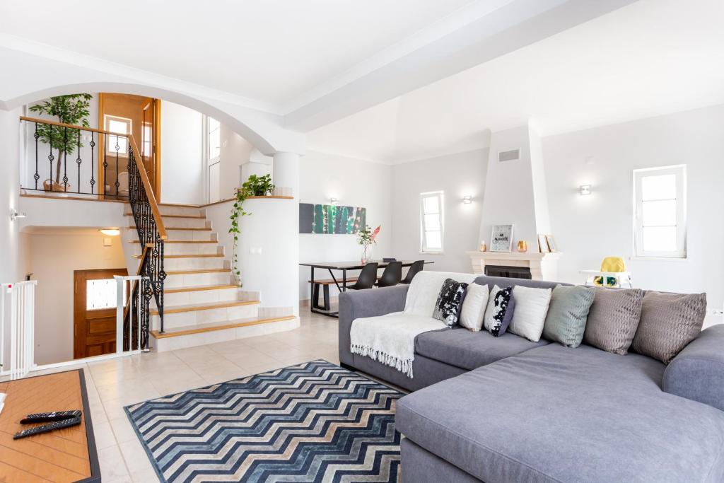 sala de estar con sofá y escalera en Newly refurbished townhouse, en Budens