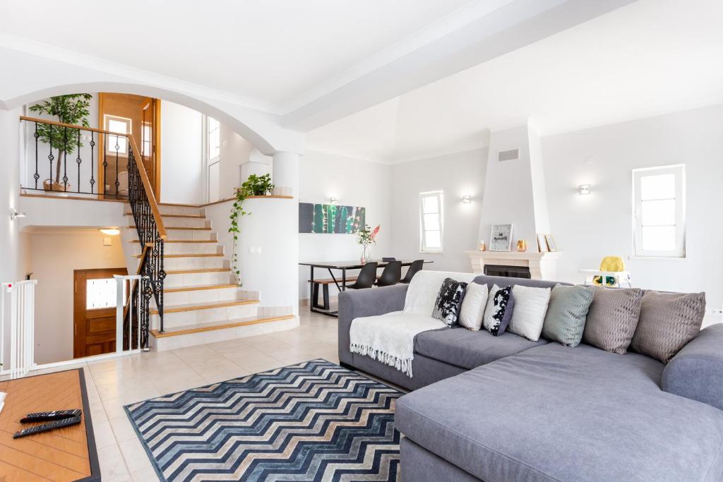 a living room with a couch and a staircase at QEV - Santo António in Budens