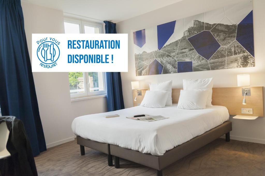 a hotel room with a bed with a sign that reads restoration programme at Brit Hotel Mâcon Centre Gare in Mâcon