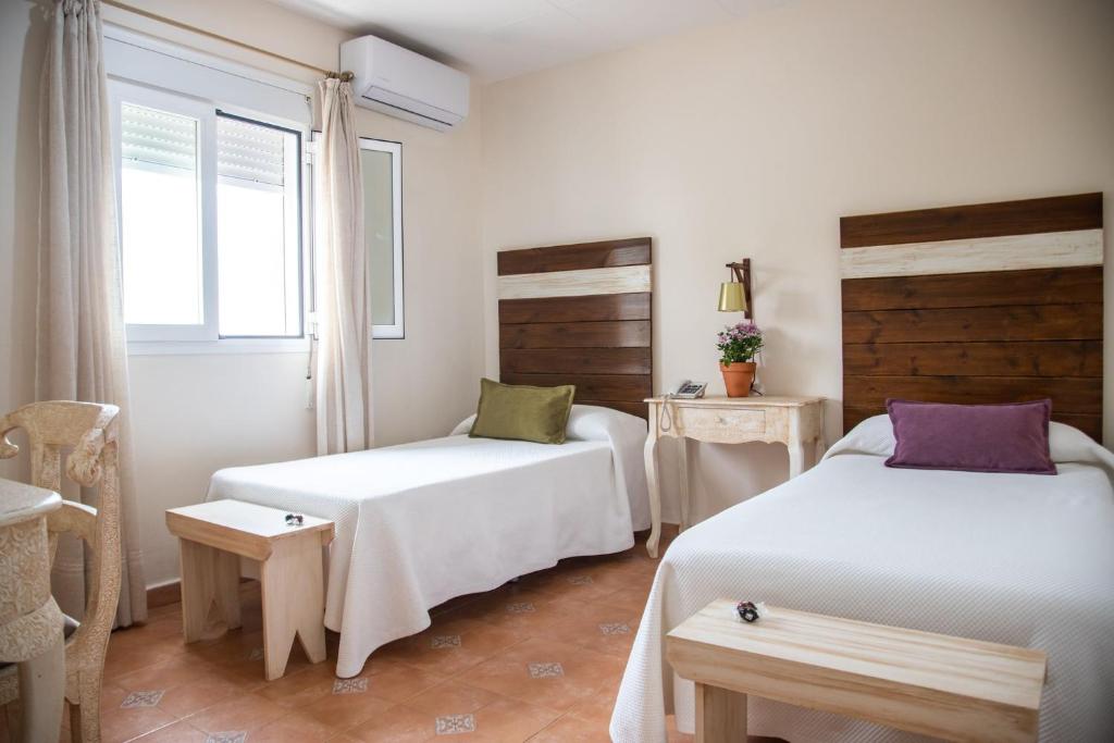 Un dormitorio con dos camas y una ventana. en Puerta de Algadir, en El Puerto de Santa María