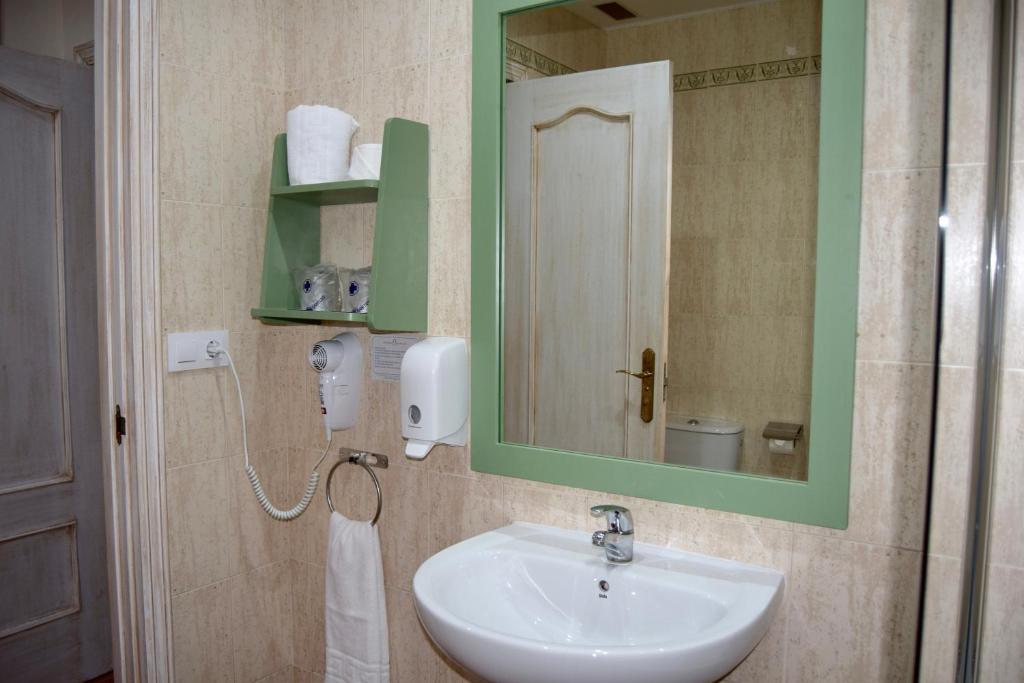un baño con lavabo y espejo en Puerta de Algadir, en El Puerto de Santa María