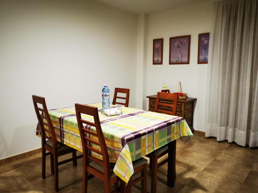 a dining room with a table with chairs and a table cloth at A Casa de Matelos in A Lanzada
