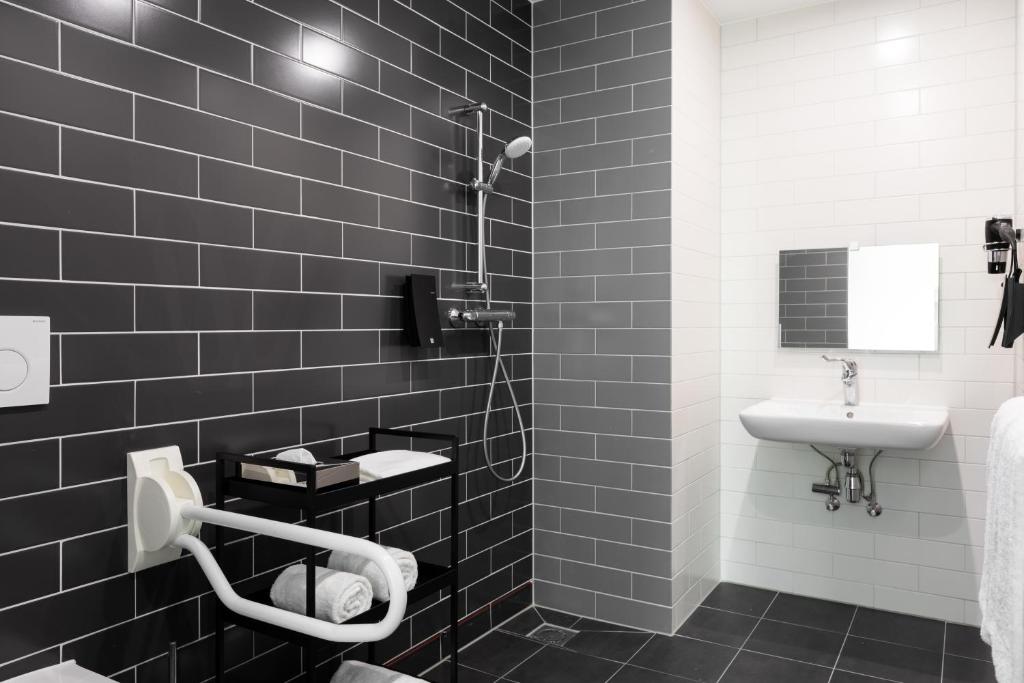 a black and white bathroom with a sink and a shower at Holiday Inn Express Amsterdam - North Riverside by IHG in Amsterdam