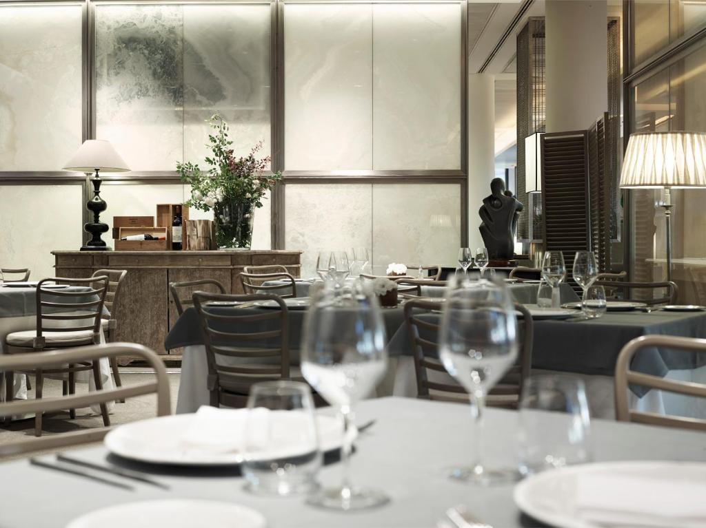 a restaurant with tables and chairs with wine glasses at Grand Hotel De La Ville in Parma