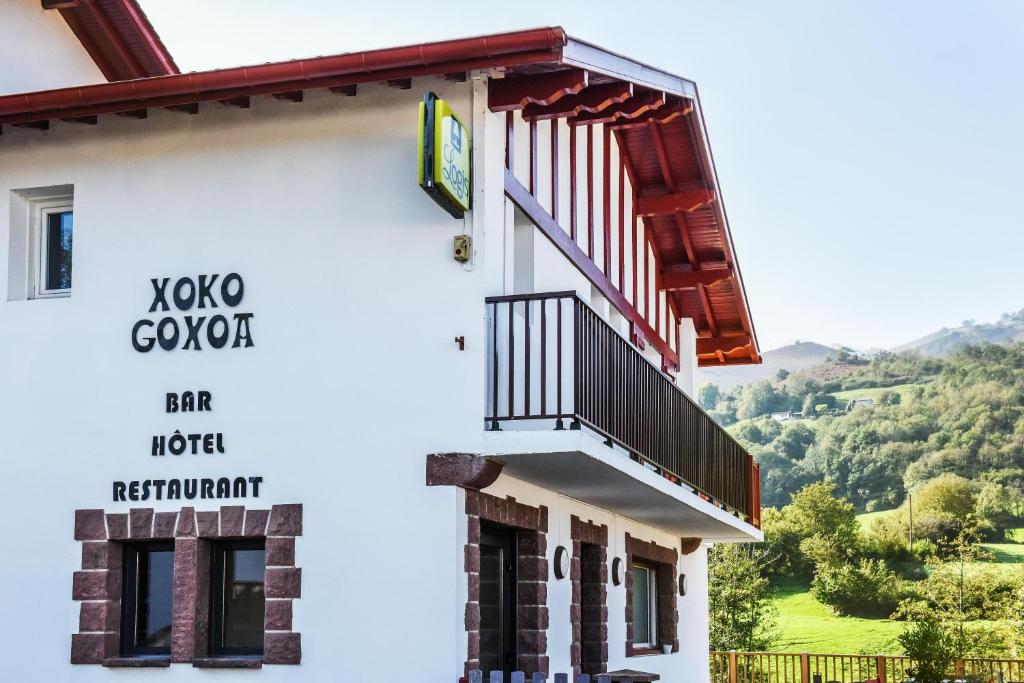 a building with a staircase and a sign on it at Logis Hotel Xoko-Goxoa in Saint-Michel