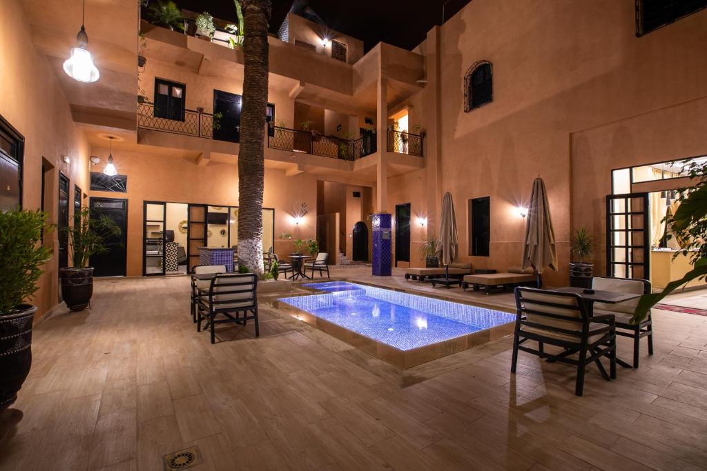 un patio con piscina en una casa en Hotel Toulousain en Marrakech