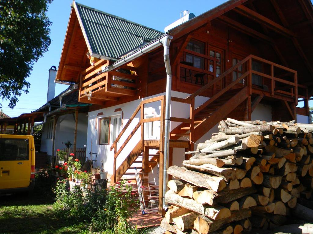 una casa con una escalera y un montón de troncos en Küküllő Vendégház, en Sovata