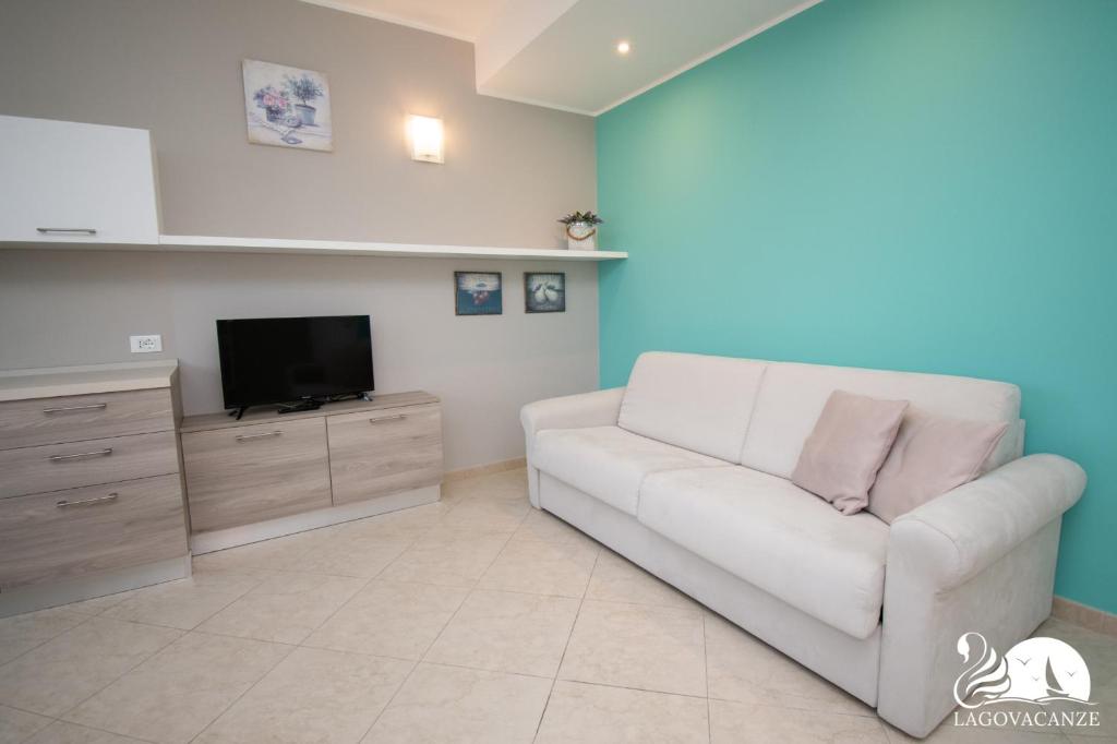 sala de estar con sofá blanco y TV en Luxury Martina Appartamenti en Moniga