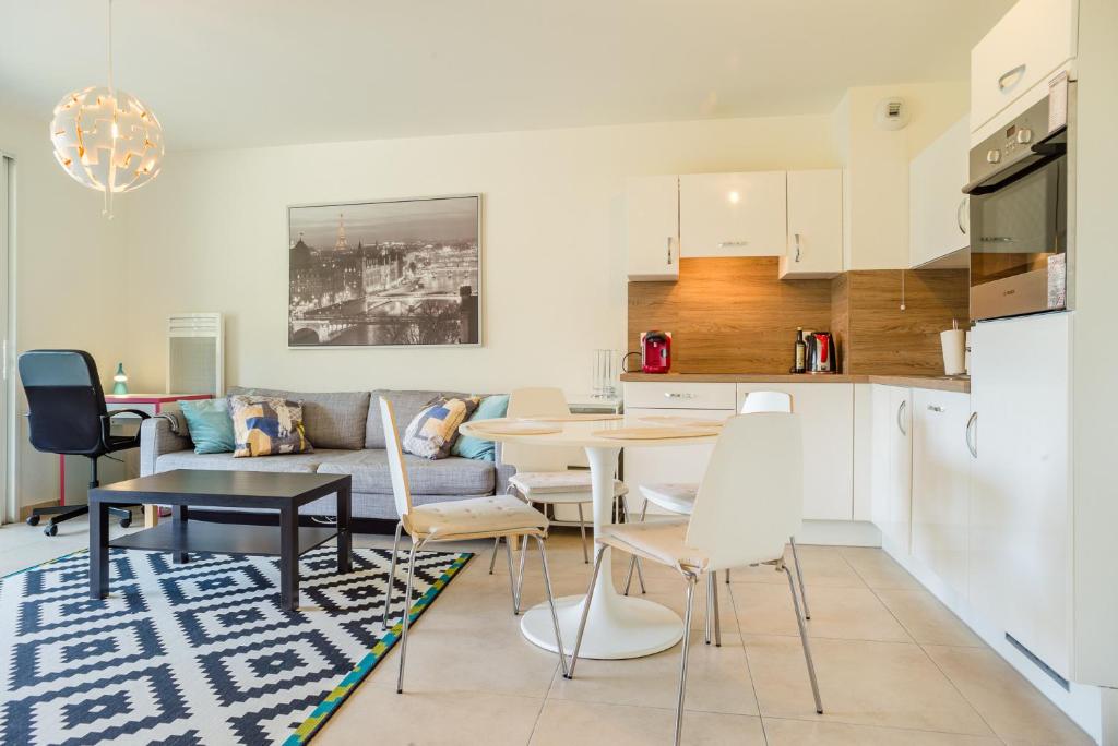 une cuisine et un salon avec une table et des chaises dans l'établissement Parc Eugenie by Welcome to Cannes, à Cannes