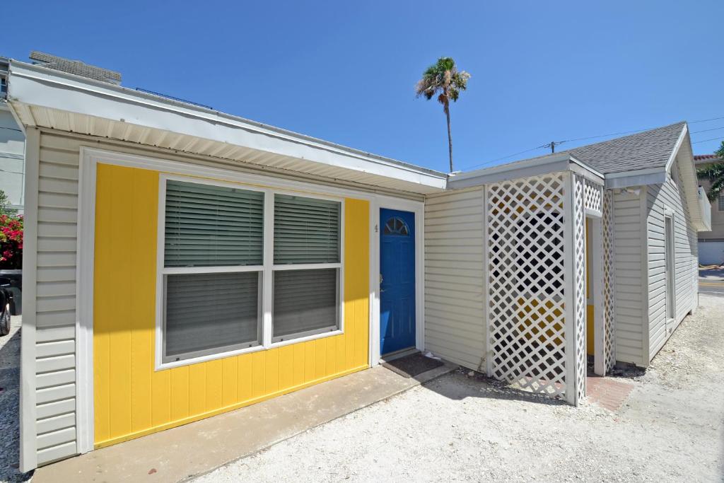 a yellow and white house with a blue door at Siesta Key Beach - Capri 665 #4 in Siesta Key