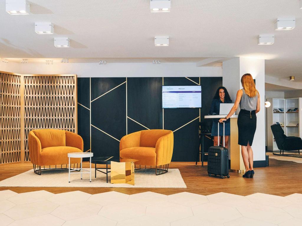 a woman is giving a presentation in a room with chairs at Mercure Marseille Canebière Vieux-Port in Marseille