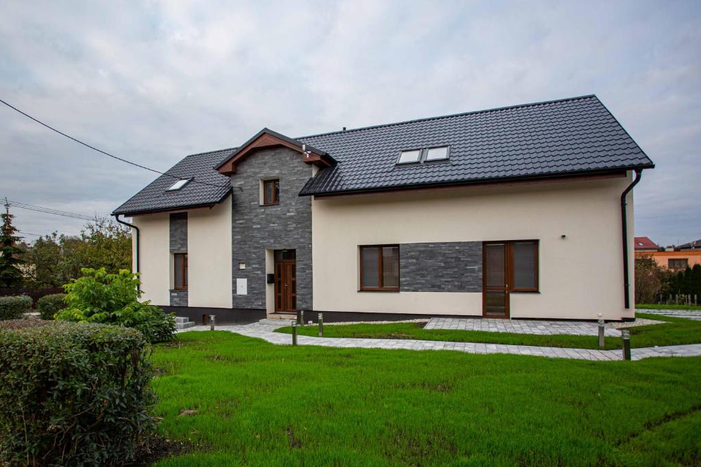 a white house with a black roof at apartmány U Solišů in Klimkovice