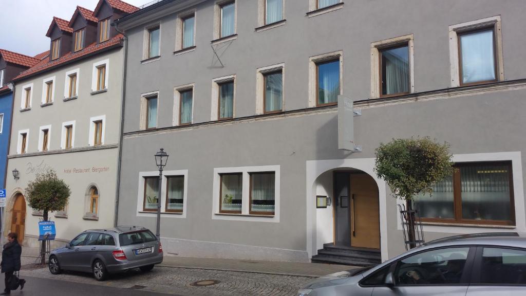 a building with a car parked in front of it at Hotel Drei Lilien in Vohenstrauß