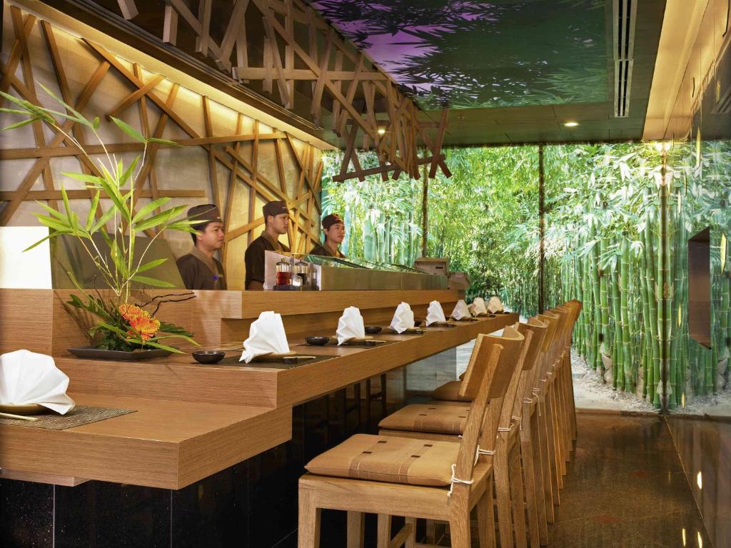 a group of people sitting at a table in a restaurant at Pullman Khon Kaen Raja Orchid in Khon Kaen