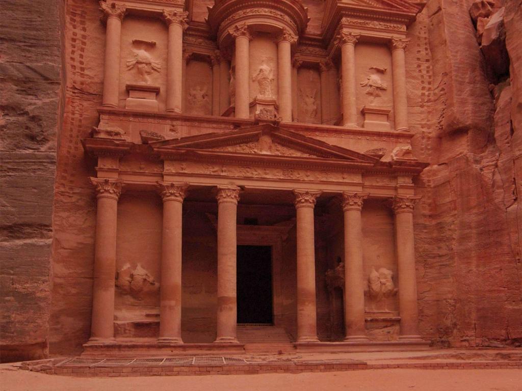 
a large stone building with a statue of a man in front of it at Mövenpick Resort Petra in Wadi Musa
