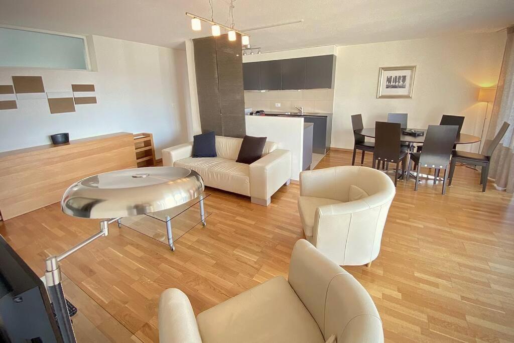 Spacious and bright 2 bedroom apartment with terrace في لوزان: غرفة معيشة مع أريكة وطاولة