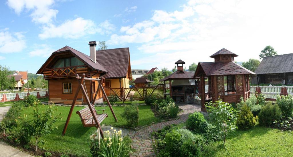 een huis met een schommel in de tuin bij Гніздо Беркута in Tukhlya
