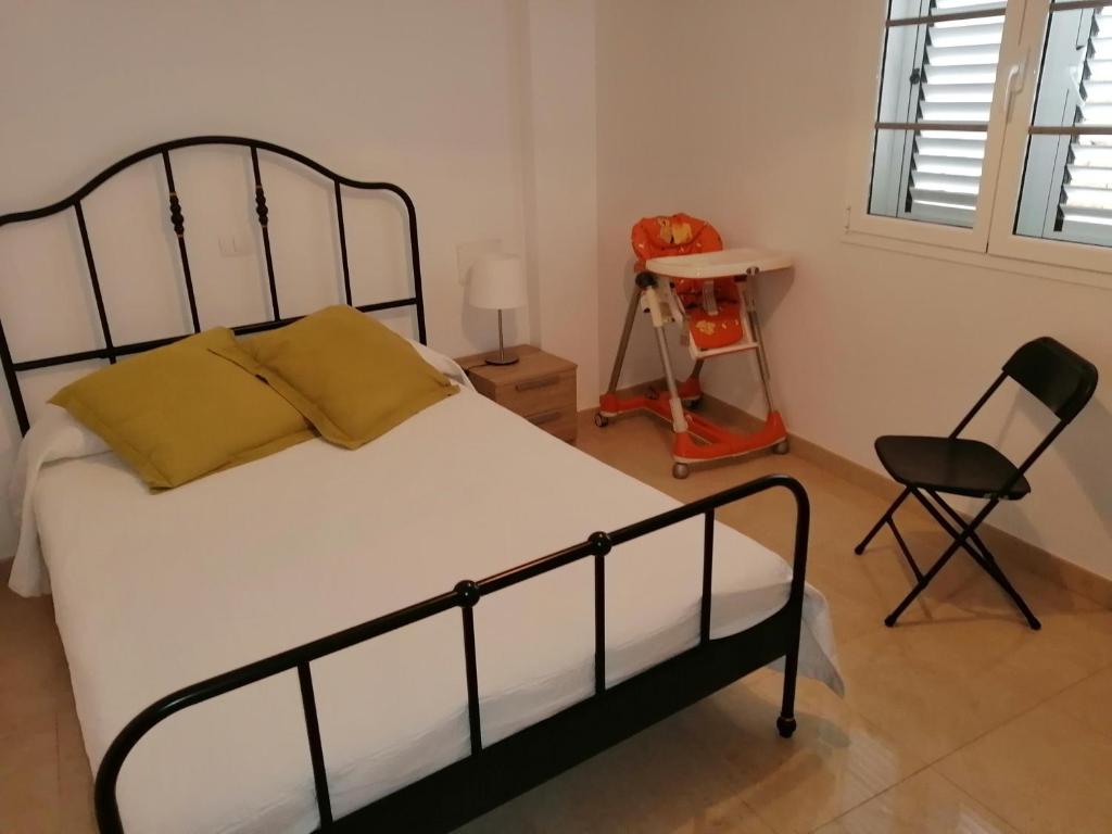 sypialnia z łóżkiem z krzesłem i biurkiem w obiekcie Casa El tonelero con jardín y piscina privada w mieście Gáldar