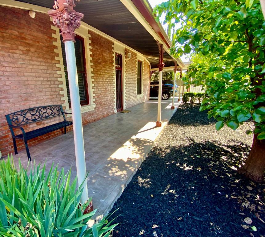 a bench sitting on the porch of a house at Somerby! in Albury