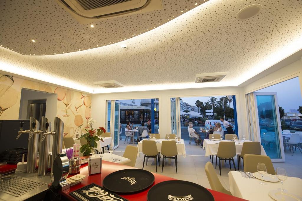 a dining room with a table and chairs and a room with people at Ocean Lounge in Altea