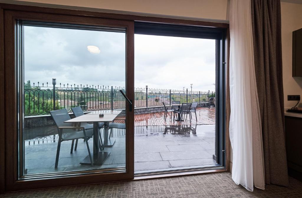 a sliding glass door leading to a patio with a table and chairs at Selini Hotel İstanbul Airport in Istanbul