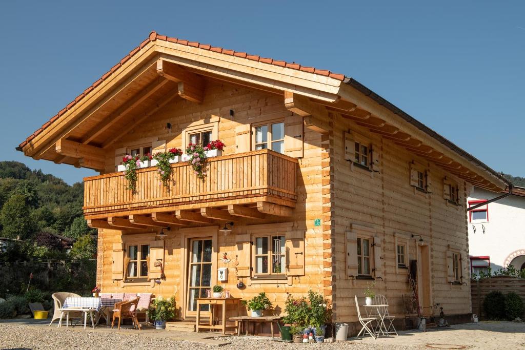 a wooden house with a balcony and a table at Alchemilla in Bad Feilnbach