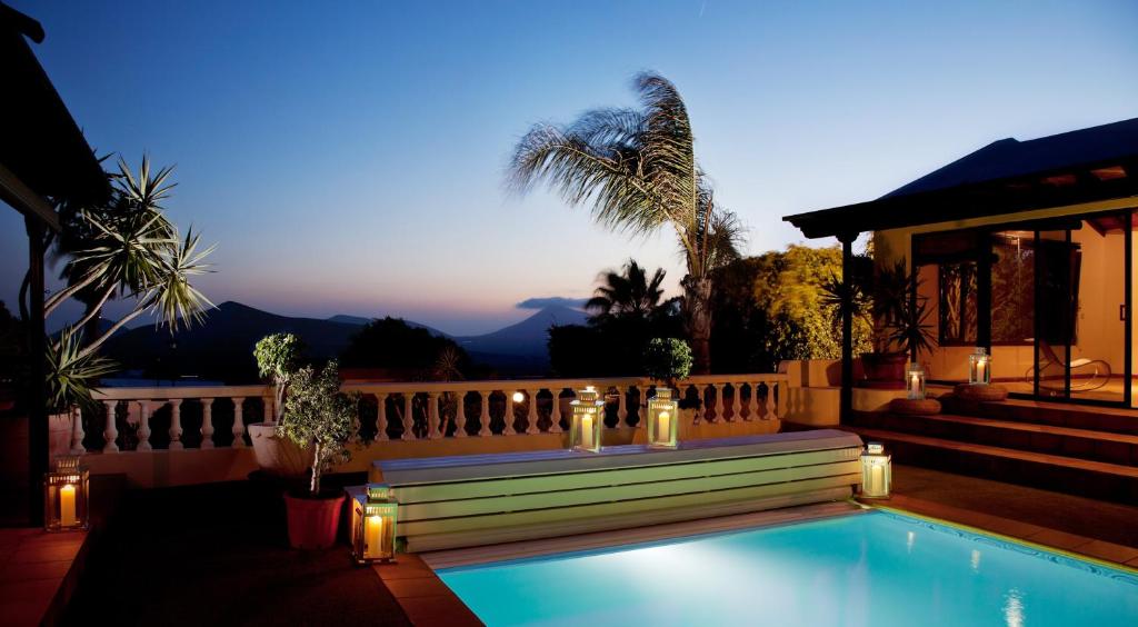 a house with a swimming pool with lights on a fence at Villa Dora Bella in Nazaret