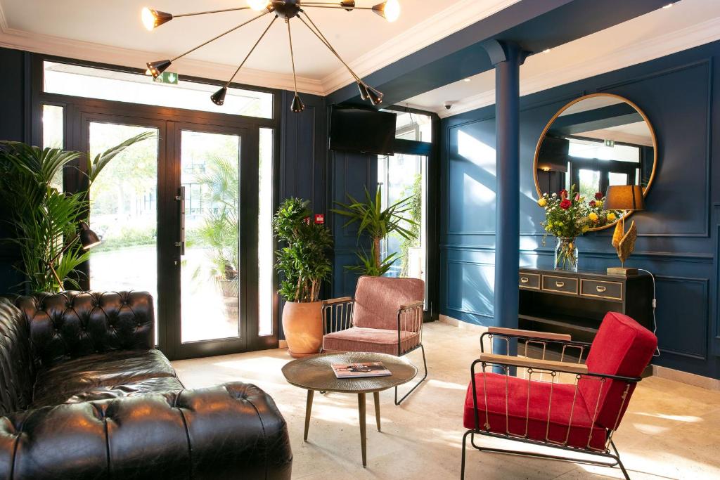 a living room with blue walls and a leather couch at Le Grand Albert 1er in Maisons-Alfort