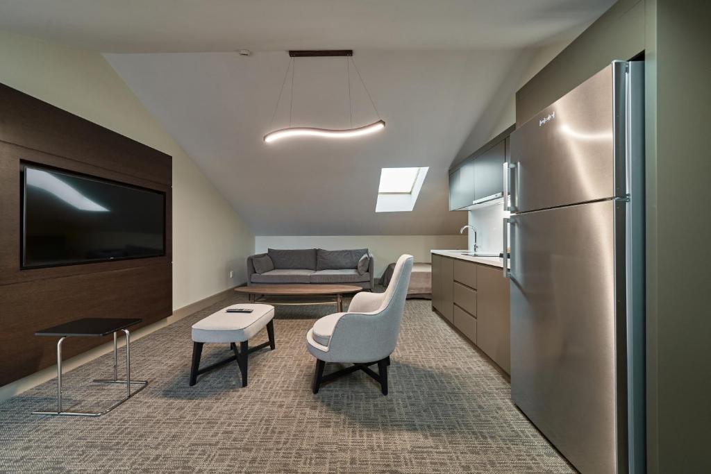 a kitchen with a refrigerator and a living room at Selini Hotel İstanbul Airport in Istanbul
