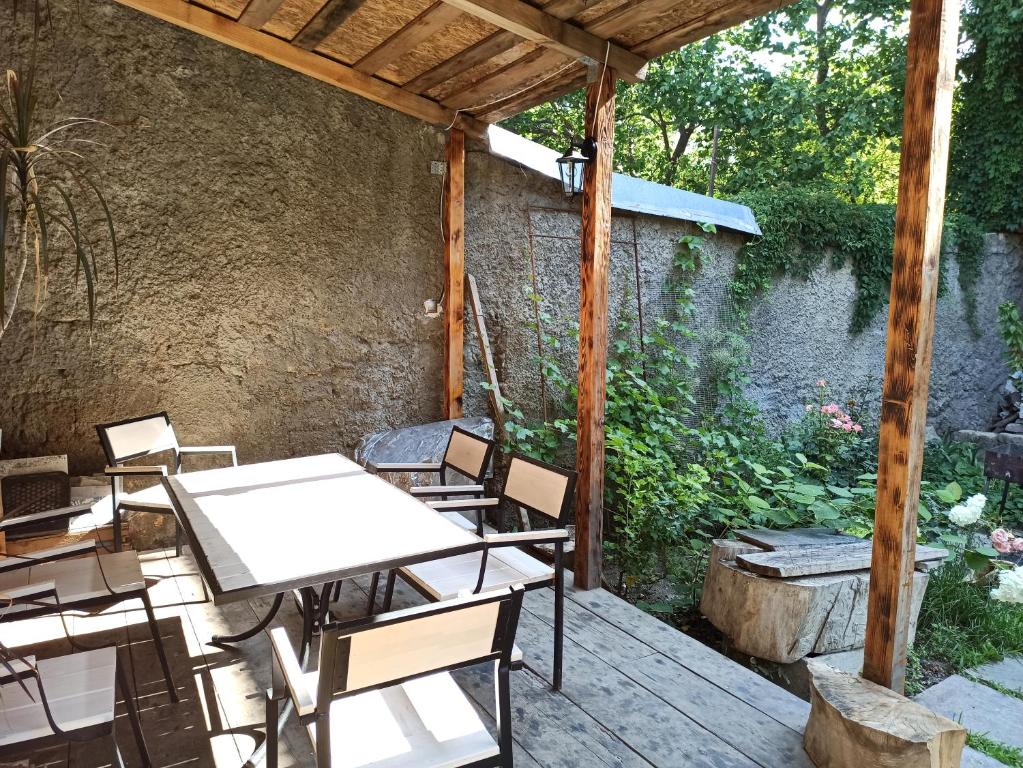 eine Terrasse mit Tischen und Stühlen und einer Steinmauer in der Unterkunft Дом у моря с бассейном и сауной in Odessa