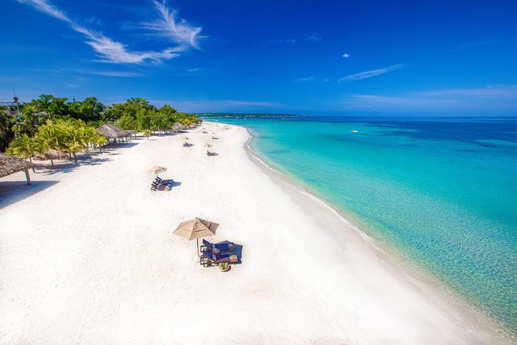 una vista aerea su una spiaggia con sedie e ombrelloni di A Wave From It All @ Aqueducts a Negril