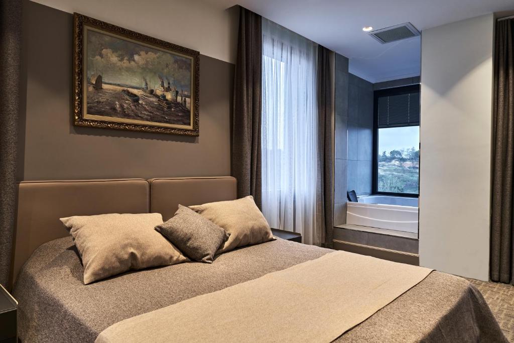a bedroom with a bed and a painting on the wall at Selini Hotel İstanbul Airport in Istanbul