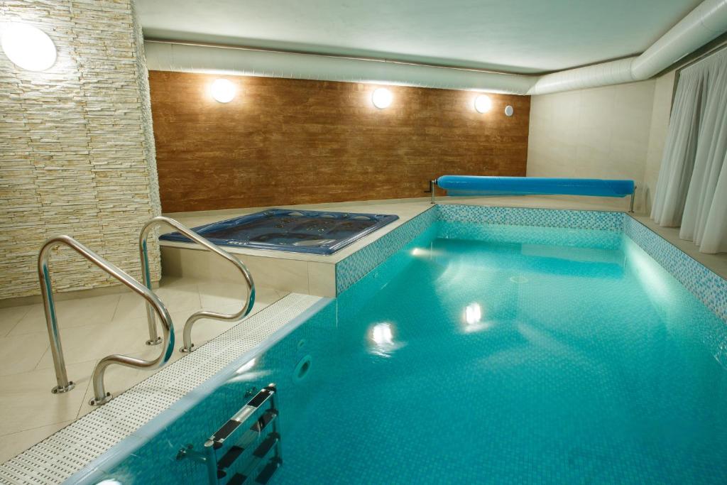 a large swimming pool in a room with a tub at Vila Terra in Luhačovice