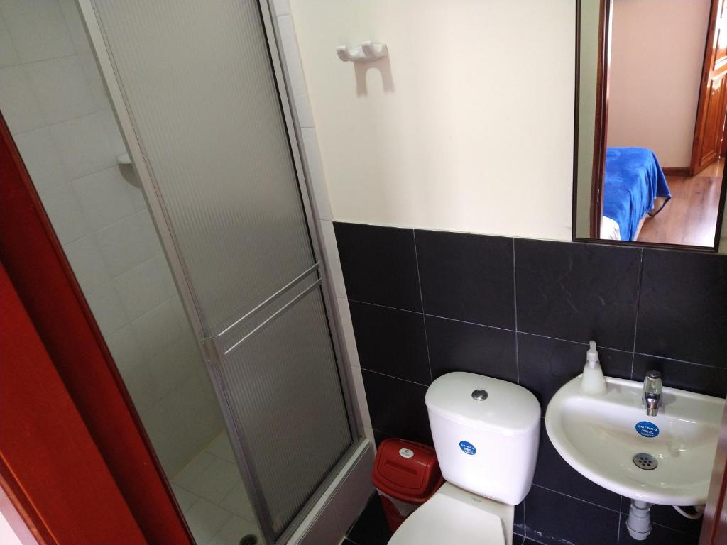 a bathroom with a toilet and a sink and a shower at Casona Hotel in Pasto