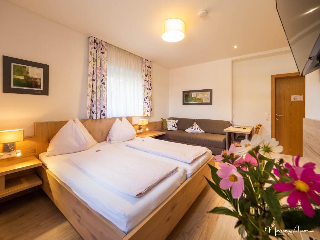 a hotel room with a bed and a couch at Pension Ehrenfried - Hotel garni in Kindberg