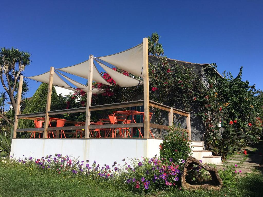 a building with a tent with chairs and flowers at Quinta das Buganvílias in Castelo Branco