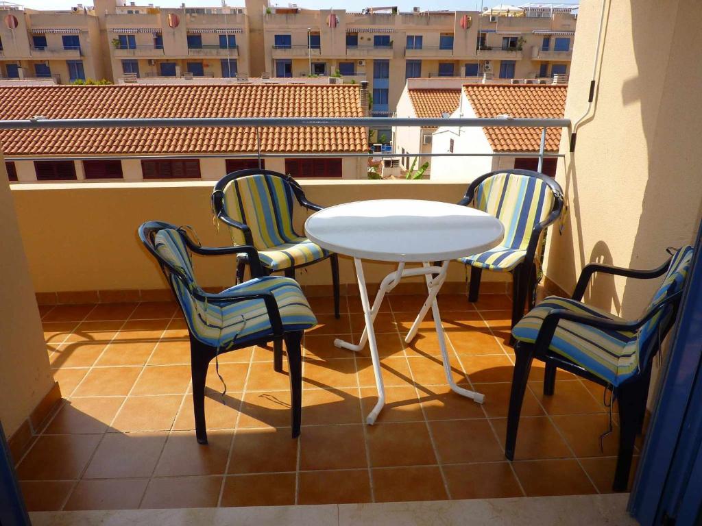 einen Tisch und 4 Stühle auf einem Balkon in der Unterkunft Mediterrania Mar Canet in Canet d'en Berenguer